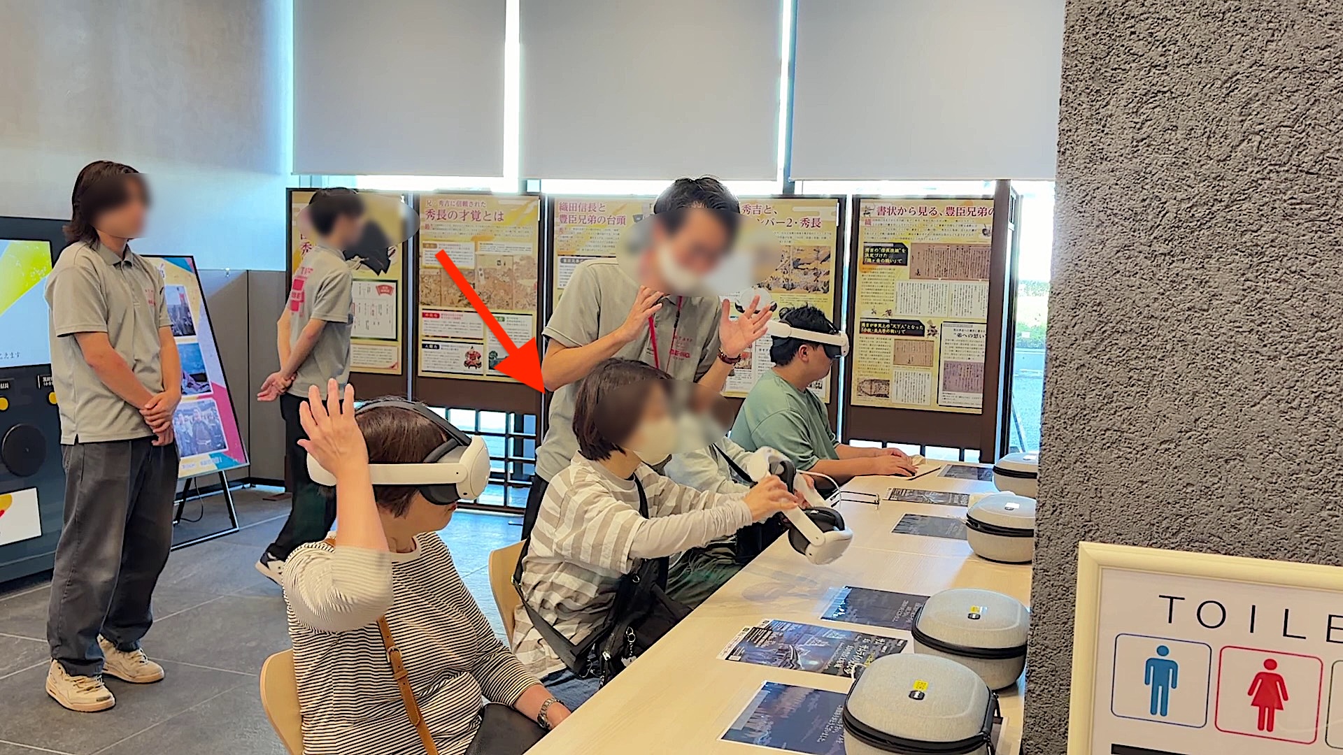 2. お客様が机の上に置かれているVRヘッドセット（ Meta Quest 3 ) を手に取ります。
